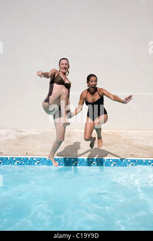Deux amis d'âge moyen de sauter dans la piscine Banque D'Images