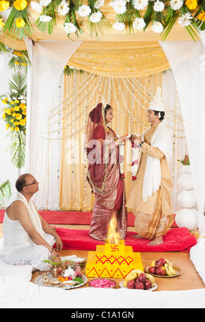 Couple d'effectuer l'échange Garland (Badal Mala) Cérémonie de mariage Bengali Banque D'Images