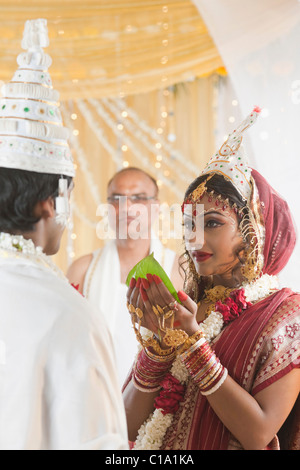 Couple giving Subho Drishti dans mariage Bengali Banque D'Images