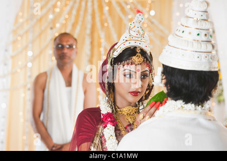 Couple giving Subho Drishti dans mariage Bengali Banque D'Images