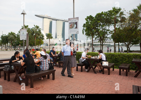 Diners à Makansutra Gluttons Bay food court avec la Marina Bays Sands Singapour dans l'arrière-plan. Marina Bay, Singapour Banque D'Images