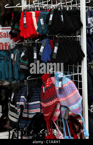 Chapeaux et gants en vente sur un stand à l'extérieur d'un magasin à Littlehampton, West Sussex, UK. Banque D'Images