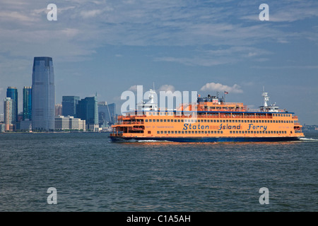 Staten Island Ferry traverse le port de New York avec Jersey Ville en arrière-plan. Banque D'Images