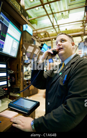 Un négociant en valeurs mobilières à l'aide d'un téléphone sur le parquet de la Bourse de New York de l'appel d'une ordonnance. Banque D'Images