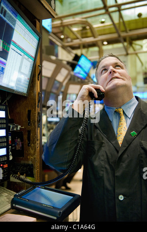 Un trader sur le parquet de la Bourse de New York qui reçoivent moins de nouvelles à travers le téléphone idéal. Banque D'Images