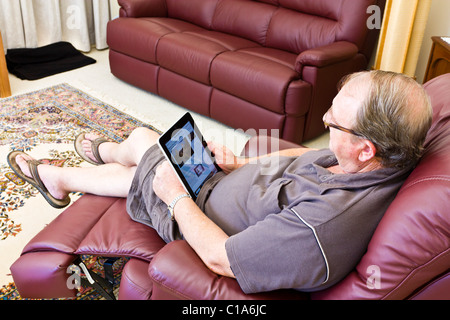 Senior Man reading newspaper Le New York Times sur son Apple iPad Banque D'Images