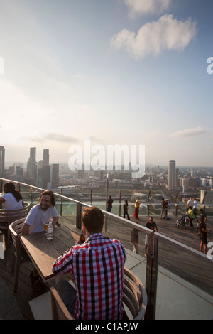 Les touristes bénéficie d'un verre au coucher du soleil pont d'observation de la Marina Bay Sands SkyPark. Marina Bay, Singapour Banque D'Images