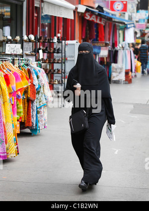 Une femmes boutiques à Whitechapel, East London - 27 juillet 2010 - tout en portant un berka (Burqa). Banque D'Images