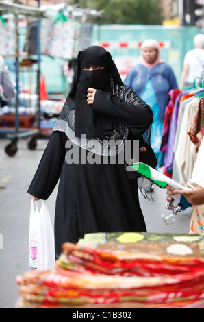 Une femmes boutiques à Whitechapel, East London - 27 juillet 2010 - tout en portant un berka (Burqa). Banque D'Images