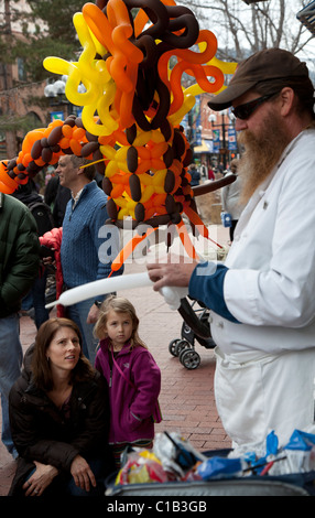 Boulder, Colorado - un homme fait fait une sculpture de ballons pour un enfant sur le Pearl Street Mall Banque D'Images