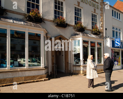 Un couple chatting en dehors de Betty's tea-room dans la High Street, dans le North Yorkshire, UK Northallerton Banque D'Images