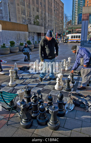 Les hommes jouent aux échecs en plein air avec le jeu d'échecs le grand parc Westlake à Seattle Washington USA Banque D'Images