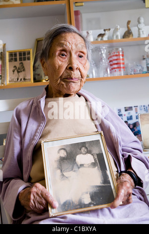 Femme tenant une photo de ses parents. Accueil pour les personnes âgées, Narsaq, au sud du Groenland. Banque D'Images