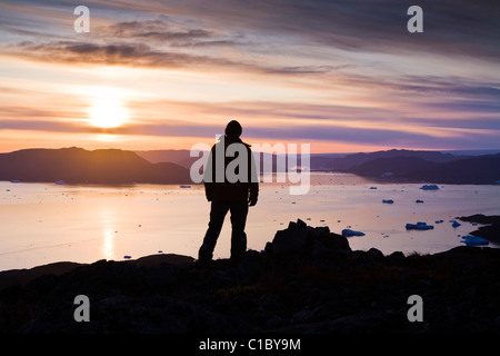 L'homme à l'extérieur du fjord à Narsaq, le sud du Groenland. Banque D'Images