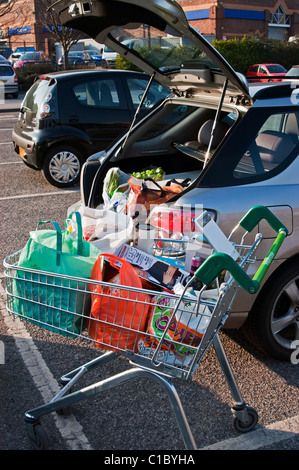 Chargement de votre voiture en chariot de supermarché Banque D'Images