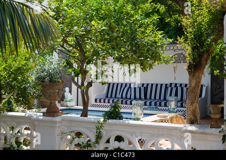 Piscine avec coin salon à l'ombre d'arbres fruitiers Banque D'Images