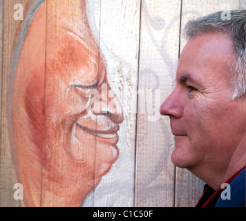La photographie de rue franche, un homme face à une peinture d'un homme, Venise, Italie Banque D'Images