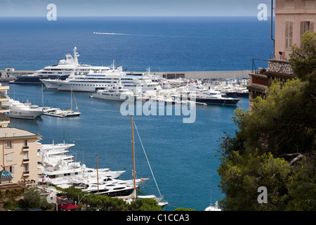 Vue vers le bas sur le port de Port Hercule à Monaco, avec de grandes et super yachts amarrés ensemble. Banque D'Images