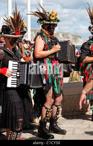 La danse morris traditionnel anglais Hommes et femmes à Rag & vestes visages noircis avec des bâtons à la fin de la saison de Swanage Folk Festival Banque D'Images