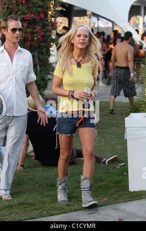 Tara Reid, portant un t-shirt jaune sans soutien-gorge, sirotant une boisson rafraîchissante avec un ami à la Coachella Music Festival 2009 Banque D'Images