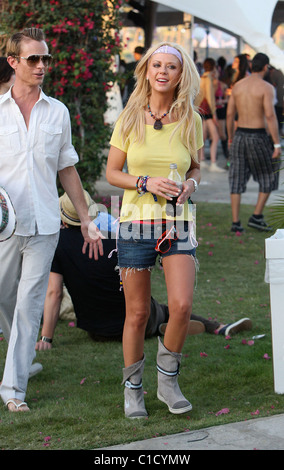 Tara Reid, portant un t-shirt jaune sans soutien-gorge, sirotant une boisson rafraîchissante avec un ami à la Coachella Music Festival 2009 Banque D'Images