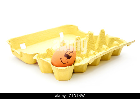 Groupe d'oeufs frais avec appelée visages illustrant diverses émotions disposés dans une boîte à œufs en carton contre le blanc. Banque D'Images