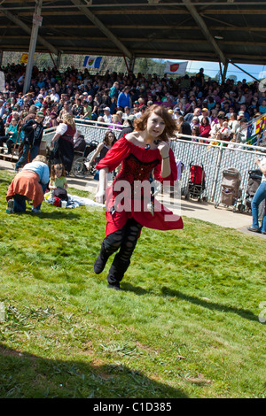 Une jeune fille à la tête rouge vêtue d'un costume pour la Sonora California Celtic faire avec la foule regardant le match Jousting derrière elle Banque D'Images