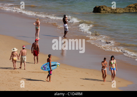 Un groupe de personnes à pied sur la côte de l'océan Atlantique. Plage de Praia da Rocha, Portimao, Algarve, PORTUGAL Banque D'Images