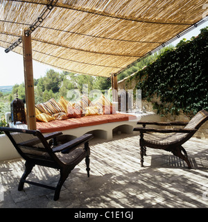 Fauteuils en bois et des sièges confortables sur terrasse avec auvent et bambou vues provençal rural Banque D'Images