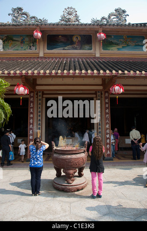 Les gens priant au temple bouddhiste Banque D'Images