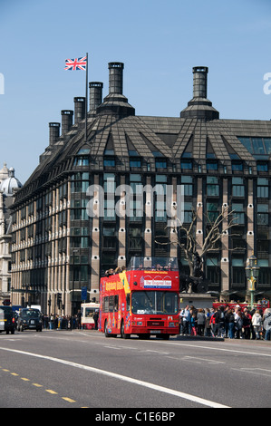 Une tournée à Londres bus passe d'un groupe de touristes sur le pont de Westminster. L'Union jack flag fichiers ci-dessus Portcullis House. Banque D'Images