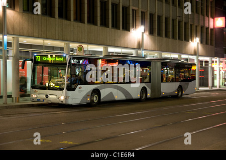 Une Mercedes-Benz Citaro articulé attend à un arrêt de bus en centre-ville de Karlsruhe dans la nuit. Banque D'Images