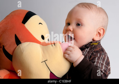 Bébé garçon de 9 mois, avec un jouet peluche Disney. Banque D'Images