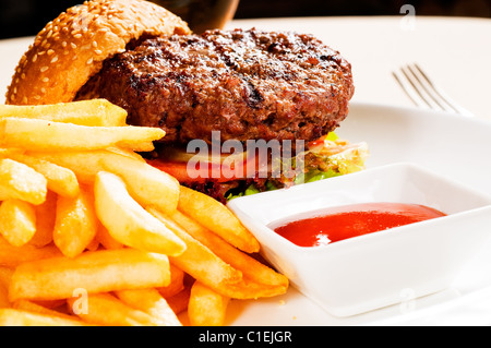 Sandwich frais hamburger américain classique avec frites et sauce ketchup sur le côté Banque D'Images