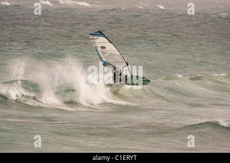 Windsurfer saute la lèvre de la vague par vent fort Banque D'Images