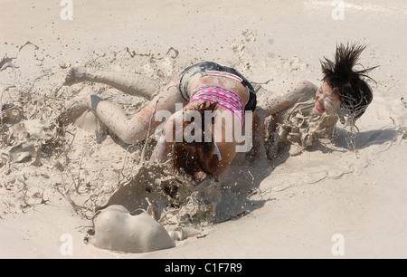 Championnats du monde Mud-Wrestling deux femelles sales dans une fosse de la pince pendant une journée internationale de la femme en cas de boue-lutte Banque D'Images