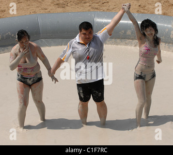 Championnats du monde Mud-Wrestling deux femelles sales dans une fosse de la pince pendant une journée internationale de la femme en cas de boue-lutte Banque D'Images