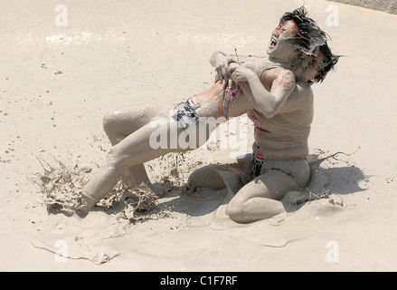 Championnats du monde Mud-Wrestling deux femelles sales dans une fosse de la pince pendant une journée internationale de la femme en cas de boue-lutte Banque D'Images