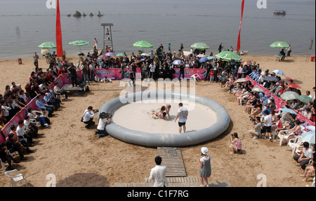 Championnats du monde Mud-Wrestling deux femelles sales dans une fosse de la pince pendant une journée internationale de la femme en cas de boue-lutte Banque D'Images