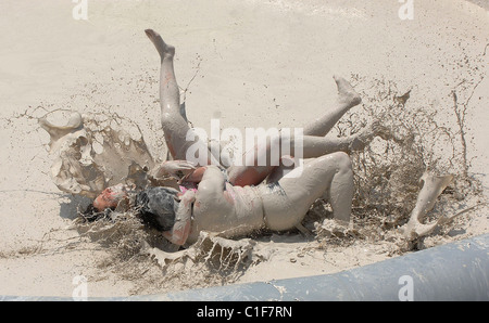 Championnats du monde Mud-Wrestling deux femelles sales dans une fosse de la pince pendant une journée internationale de la femme en cas de boue-lutte Banque D'Images