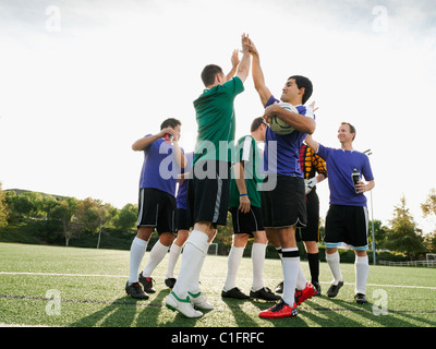 Joueurs de football se réjouissant de terrain de soccer Banque D'Images