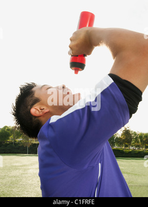 Joueur de football d'Asie l'eau potable sur le terrain de soccer Banque D'Images