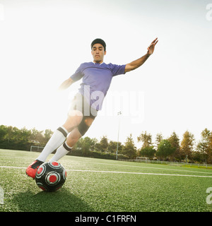 Race mixte soccer player kicking soccer ball Banque D'Images