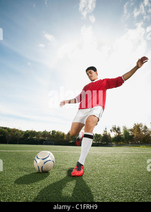 Race mixte soccer player kicking soccer ball Banque D'Images