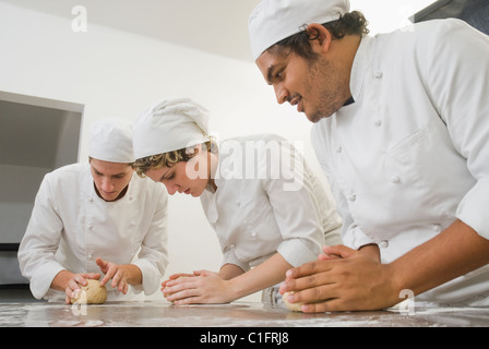 Les boulangers travaillent avec la pâte en cuisine boulangerie Banque D'Images