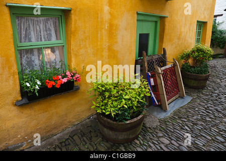 Cottage avec traîneaux laissés à l'extérieur, Clovelly, Devon, Angleterre Banque D'Images