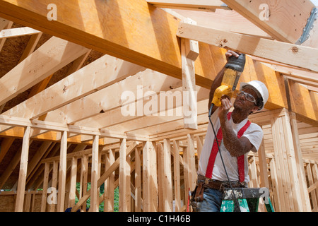 Charpentiers hispanique à mouvement alternatif, à l'aide de chevrons sur un toit sur une maison en construction Banque D'Images