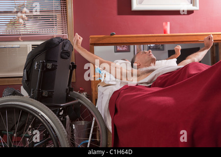 L'homme avec la moelle épinière qui s'étend sur le lit Banque D'Images