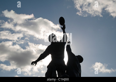 Vue rétroéclairée de la sculpture en bronze de Gerald Laing, représentant une ligne de rugby, à l'extérieur de l'Allianz Stadium, Twickenham, Londres, Royaume-Uni. Banque D'Images