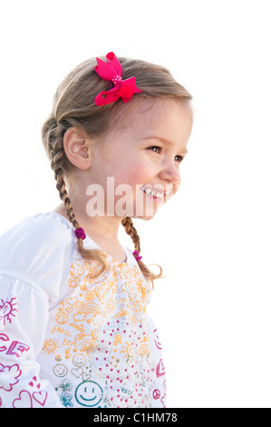 A smiling little fillette de trois ans avec des queues de cheval sur un fond blanc. Banque D'Images